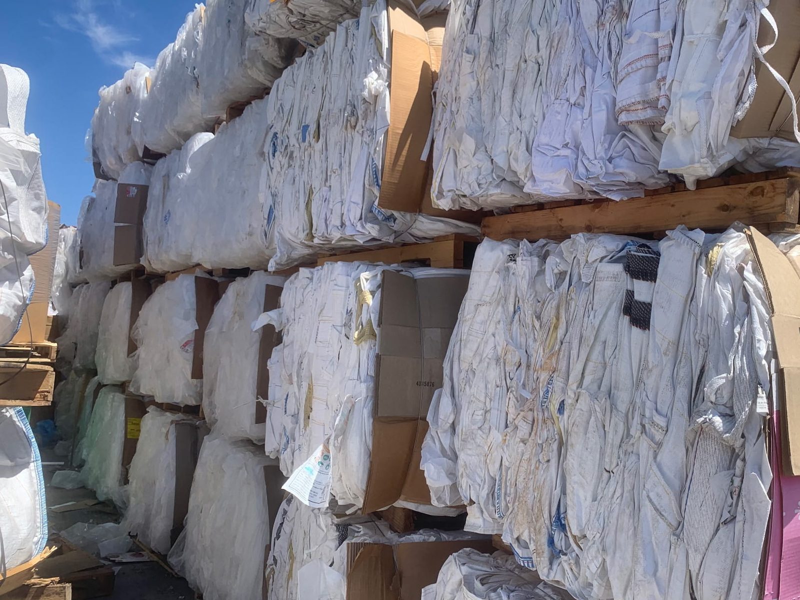 Baled recovered material stacked and strapped in the yard, ready for container loading
