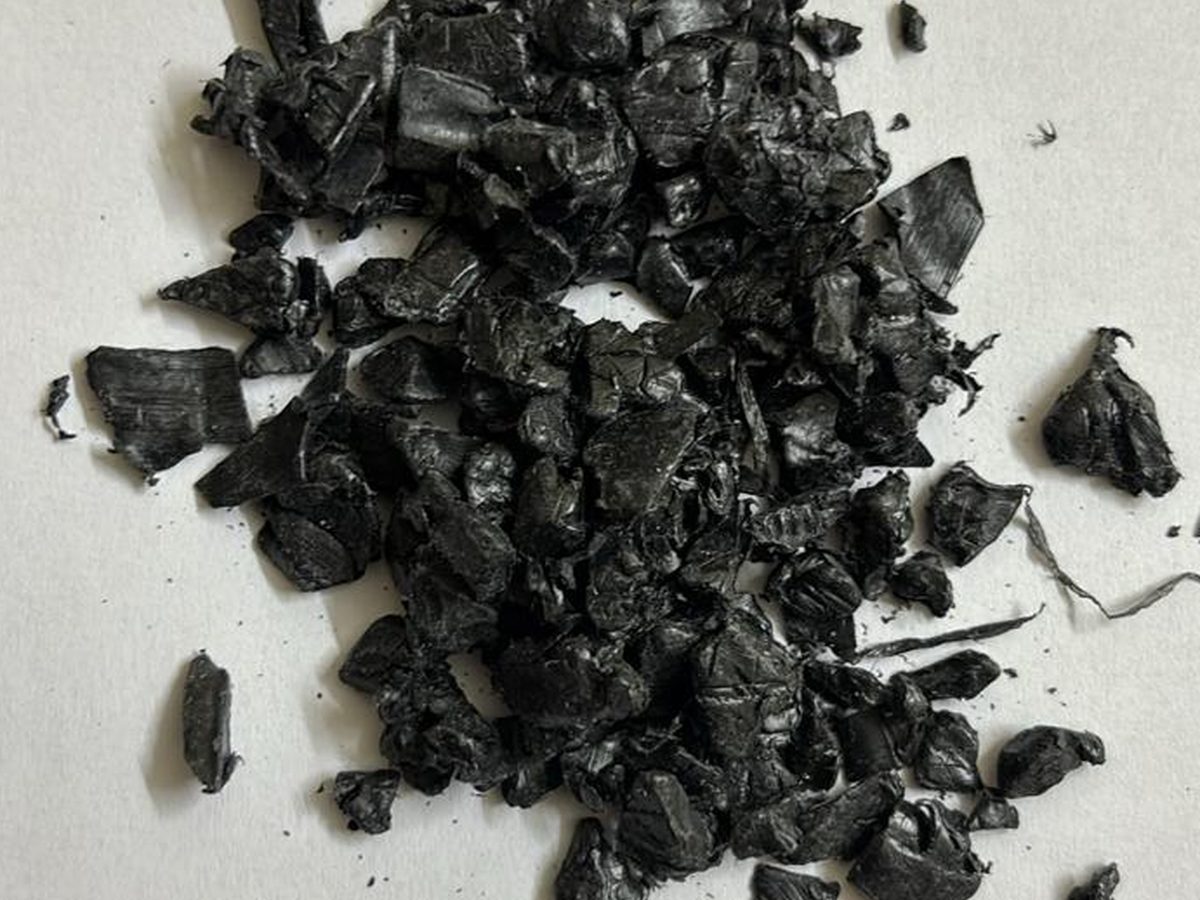 Black rigid regrind chips on a neutral background