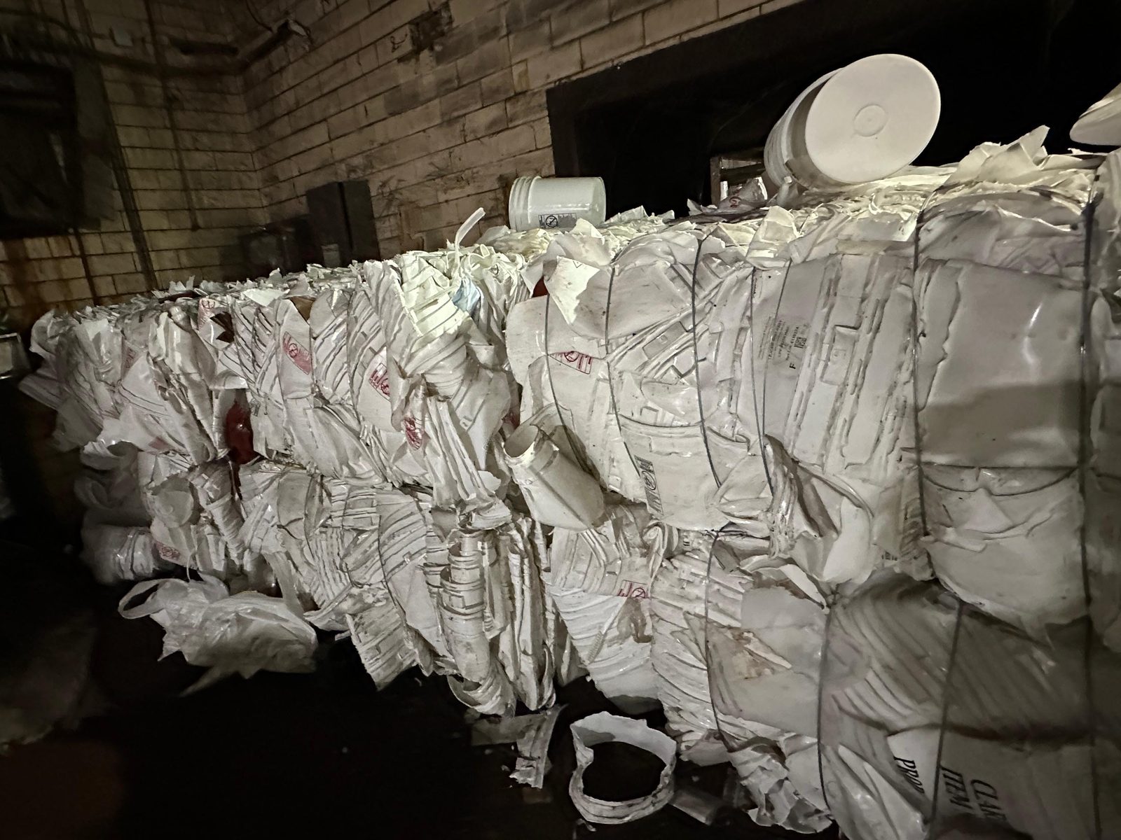 Rows of sorted, baled material lined up along the warehouse floor